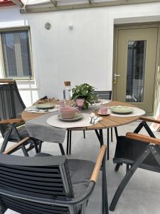 a table and chairs with plates and bowls on it at Olive green house in Skiathos
