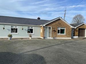 a house with a driveway in front of it at Smarmore Cottage in Ardee