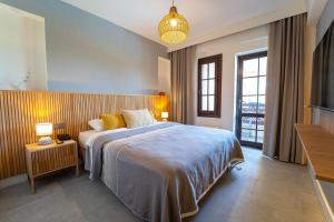 a bedroom with a large bed and a large window at Hotel Club-E in Fethiye