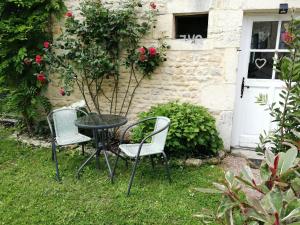 a table and chairs in front of a house at Séjour à la campagne in Bouhy