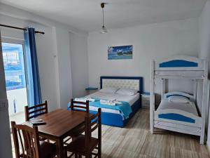 Schlafzimmer mit einem Tisch, einem Bett und Etagenbetten in der Unterkunft Romantika in Shëngjin