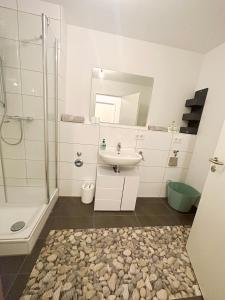 un bagno bianco con lavandino e doccia di Seductive 1-Room Apt, Centre of Stuttgart a Stoccarda