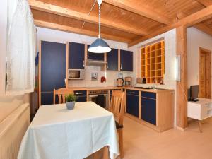 a kitchen with a table and a kitchen with blue cabinets at Cozy Apartment in Rerik with Sea Near in Rerik