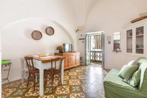Salentoandmore - Casa della Nonna في مورتشانو دي ليوكا: غرفة معيشة مع طاولة ومطبخ