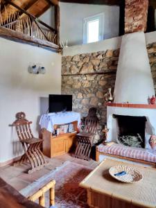 sala de estar con chimenea de piedra y mesa en Maison adorée, en Vrasná