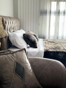 a bed with two pillows and a couch in a room at City Center Cacak in Čačak +11 photos