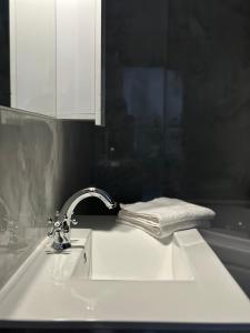 a bathroom sink with a faucet and a towel at City Center Cacak in Čačak +11 photos
