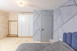 een slaapkamer met een blauw bed en een bakstenen muur bij Villa Azul - Pool, Garden, BBQ in Pefkochori