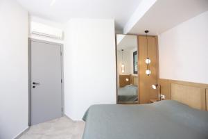 een slaapkamer met een bed en een spiegel bij Villa Azul - Pool, Garden, BBQ in Pefkochori