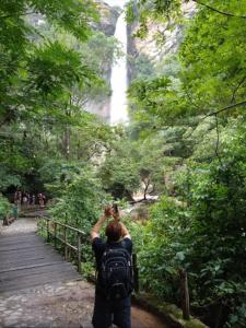 a man taking a picture of a waterfall at Suíte Casal - Queen's Hotel in Formosa