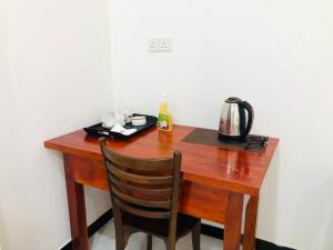 a wooden table with a tea kettle and a chair at Renaissance Villa Bentota in Bentota