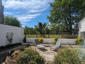 einen Garten mit zwei Stühlen und einem Zaun in der Unterkunft Grande maison avec extérieur, jacuzzi et billard in Vierzon