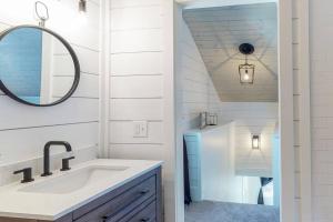 a white bathroom with a sink and a mirror at The Towpath Retreat-A Cozy Farmhouse Stay in Canal Fulton +22 photos