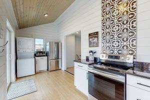 a kitchen with white cabinets and a stove top oven at The Towpath Retreat-A Cozy Farmhouse Stay in Canal Fulton