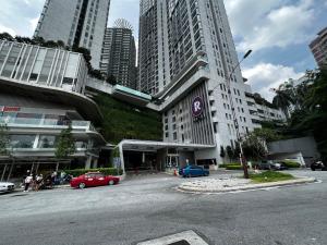 a street with cars parked in front of a building at Eclipse Suites Robertson Bukit Bintang in Kuala Lumpur
