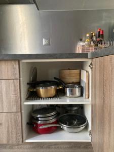 a kitchen with some pots and pans on a shelf at Nice west cosy flat balcony, near airport, train, beach, public transport, supermarket, comfortable and well equipped in Nice