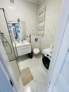 a bathroom with a shower and a toilet and a sink at Apartament Studzienna in Elblag +3 photos