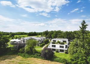 - une vue aérienne sur un grand domaine avec des maisons dans l'établissement Golfhotel Gut Neuenhof, à Fröndenberg/Ruhr