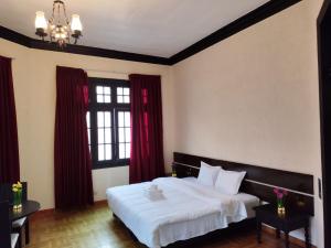 a bedroom with a large white bed with red curtains at GREEN ORCHID HOSTEL Miraflores Lima in Lima
