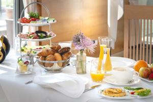 a table with breakfast foods and drinks on it at Golfhotel Gut Neuenhof in Fröndenberg