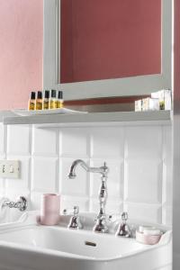 een wastafel in de badkamer met een spiegel en een plank erboven bij Villa Erbaia Relais de Charme in Barberino di Mugello