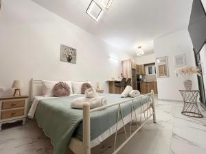 een slaapkamer met een bed met kussens erop bij Corfu Airport Sweet Studio in Ágios Rókkos