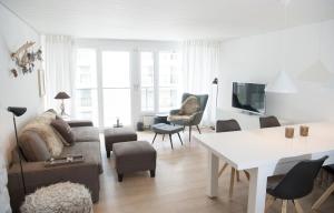 a living room with a couch and a table at Stylish apartment with mountain view in Lenzerheide