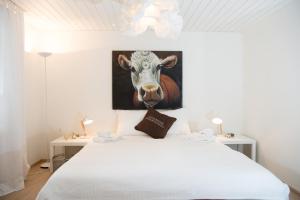 a bedroom with a bed with a picture of a cow at Stylish apartment with mountain view in Lenzerheide