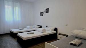 two beds in a room with white walls at Apartament 3 camere Hd in Hunedoara
