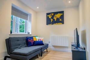 a living room with a couch and a tv at Guest Homes - Sedlescombe Apartment in Rugby