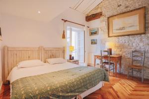 Schlafzimmer mit einem Bett, einem Tisch und einem Schreibtisch in der Unterkunft Villa Le Passe simple in Saint-Martin-de-Ré