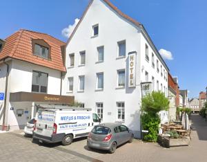 a van parked in front of a white building at Hotel Samson in Beckum