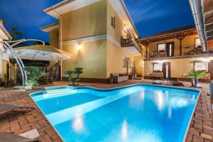 a swimming pool in front of a villa at Penzión Heléné in Veľký Meder