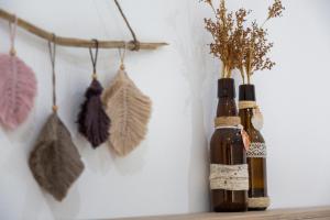 two bottles with dried leaves on a wall at Kiteriders Garden Villas in Ulcinj