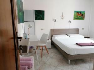 a bedroom with a bed and a desk and a chair at Seahorse B&B in Alghero