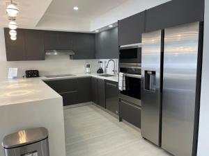 una cucina con mobili neri e un frigorifero in acciaio inossidabile di Amazing Ocean View! 10 floor Parking included a Sunny Isles Beach