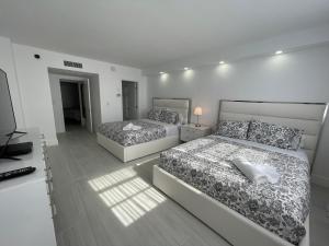 una camera da letto con due letti e una televisione di Amazing Ocean View! 10 floor Parking included a Sunny Isles Beach