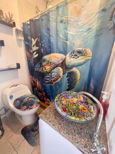 baño con cortina de ducha de tortuga y aseo en Surf City-Atami Solárium beach house near el Tunco, en Tamanique