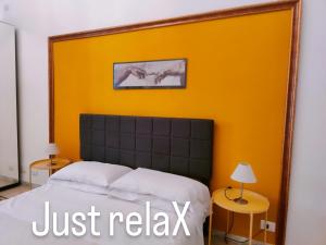 a bedroom with a bed with a yellow wall at AcB Vaticano Suites in Rome