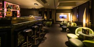um bar com bancos verdes e um balcão em De Keyser Hotel em Antuérpia