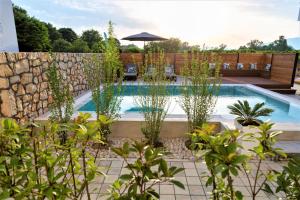 a swimming pool in a garden with plants at Kiteriders Garden Villas in Ulcinj