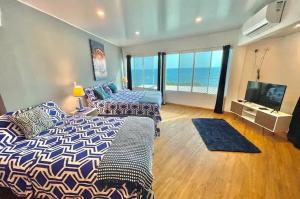 Un dormitorio con una cama, un sofá y un televisor. en Surf City-Atami Solárium beach house near el Tunco, en Tamanique