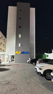 een parkeerplaats met auto's voor een gebouw bij Hotel Fly - Aeroporto Cuiabá in Várzea Grande