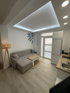 Una sala de estar con un sofá y una cocina. en Apartamento Andalucía 33 Derecha, en Málaga