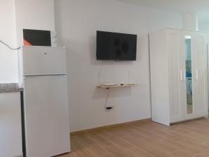 a room with a refrigerator and a tv on a wall at Apartamento Veramar en Fuengirola in Fuengirola
