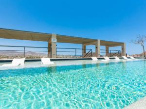 una piscina con sillas blancas en el agua en Dream At Cardinal Living, en Cabo San Lucas
