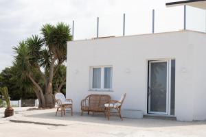 a group of chairs sitting outside of a white building at Bellavista Kamarina Resort in Scoglitti