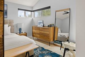 a bedroom with a bed and a dresser and a mirror at Highlands Square Bungalow - Private Yard - Garage in Denver