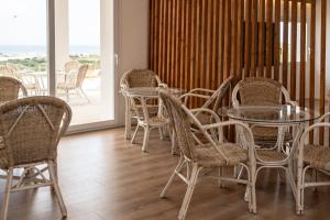 a room with tables and chairs and a balcony at Bellavista Kamarina Resort in Scoglitti