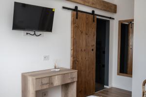 a room with a tv on a wall with a wooden door at Bellavista Kamarina Resort in Scoglitti